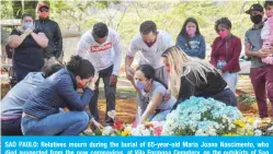  ?? — AFP ?? SAO PAULO: Relatives mourn during the burial of 65-year-old Maria Joana Nascimento, who died suspected from the new coronaviru­s, at Vila Formosa Cemetery, on the outskirts of Sao Paulo, Brazil.