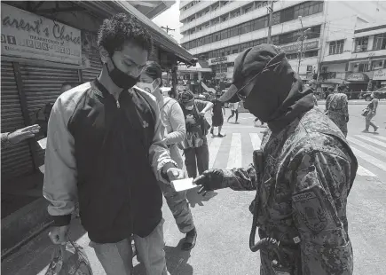  ?? Photo by Jean Nicole Cortes ?? TIGHTENED SECURITY. Personnel deployed at the Baguio City market is doubled after Saturday’s market nightmare. Police check the quarantine pass before entry to the market and make sure social distancing is observed.