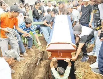  ??  ?? Friends and family members lower the coffin of Lopez into the ground during his funeral, in Masaya, Nicaragua. — Reuters photo