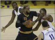  ?? BEN MARGOT — THE ASSOCIATED PRESS ?? LeBron James drives between Warriors forward Draymond Green, top, guard Klay Thompson (11) and forward Kevin Durant during Game 2.