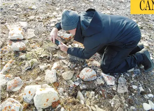  ?? ANDREW STIRLING / THE CANADIAN PRESS ?? Douglas Stenton of the University of Waterloo documents remains in the grave of a Franklin Expedition officer on King William Island in Nunavut.