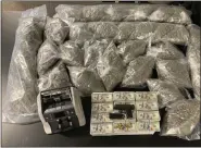 ?? PHOTO — MACOMB COUNTY SHERIFF’S OFFICE ?? Macomb County Sheriff’s road patrol deputies display some of the marijuana and weighing scales they took off a motorist in an early morning arrest in New Haven.