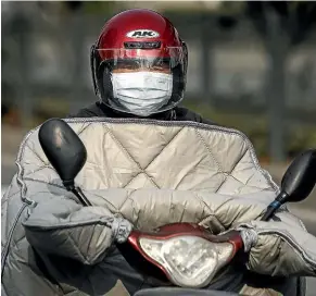  ?? GETTY IMAGES ?? A resident of Wuhan, a heavily polluted city that already had a high rate of respirator­y illnesses.