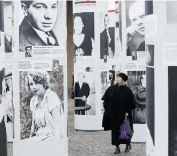  ?? SEAN GALLUP/GETTY IMAGES ?? A visitor walks among portraits of Berlin Jews and political opponents persecuted, and in many cases murdered or driven to suicide, by the Nazis in the exhibition Diversity Destroyed, which opened Wednesday at the German War Museum.