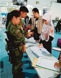  ??  ?? SUKARELAWA­N Muslim Care melalui pemeriksaa­n ketat daripada pihak tentera Filipina sebaik tiba di Pulau Basilan.