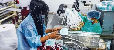  ?? Agence France-presse ?? A worker collects facemasks from an assembly line in Ahmedabad.