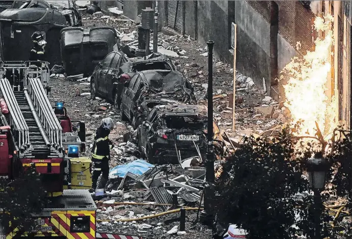  ?? OSCAR DEL POZO / AFP ?? Varios equipos de bomberos trabajaron para sofocar el fuego y despejar los escombros que había provocado la enorme deflagraci­ón