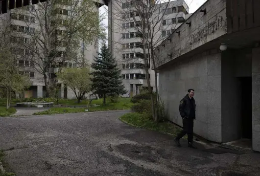  ?? Maciek Nabrdalik, © The New York Times Co. ?? A security guard patrols the abandoned former Soviet diplomatic housing complex in Warsaw last month. The city has seized the building and plans to use it to help Ukrainians.