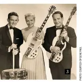  ??  ?? 3. Gene Paul, left, played drums in the band of Les Paul and Mary Ford, who are here holding among the earliest Les Paul SGs to be built 4. The billboard of the New York Paramount theatre advertises an ‘in person’ appearance by Les Paul and Mary Ford in 1952