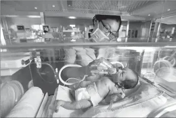  ?? SI WEI / FOR CHINA DAILY ?? A newborn is cared for
