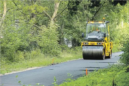  ?? ANDREJ IVANOV WATERLOO REGION RECORD ?? Constructi­on workers pave the Iron Horse Trail near Victoria and Strange Streets in Kitchener on Monday.