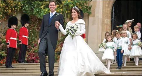 ??  ?? Princess Eugenie of York and her husband Jack Brooksbank emerge from the West Door of St George’s Chapel, Windsor Castle, in Windsor, yesterday after their wedding ceremony.
