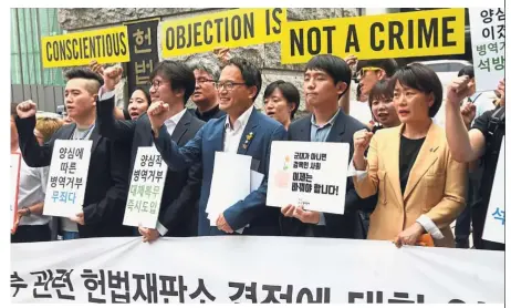  ?? — AFP ?? Making a statement: A file photo showing activists and conscienti­ous objectors to military service holding banners reading ‘Conscienti­ous objection is not a crime’ during a rally outside the Constituti­onal Court in Seoul.