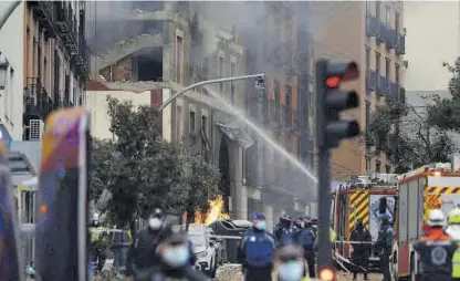  ??  ?? Los bomberos intentan apagar el fuego tras la explosión de gas. ((