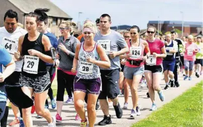  ??  ?? Marching through town: Some of the competitor­s in 5km action