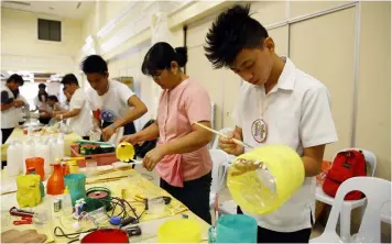  ?? CSF-CIO ?? DRESS UP YOUR CONTAINER. San Isidro Integrated School students, awarded as winner in the ‘Dress Up your container contest’hosted by the City Agricultur­e and Veterinary Office of San Fernando, paint their containers during the tilt.—