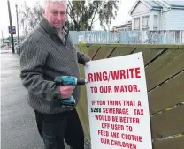  ?? PHOTO: RICHARD DAVISON ?? Battle won . . . Balclutha pensioner Bruce Graham takes down his protest sign in Clyde St yesterday, after claiming victory in a threeyear rates battle with the Clutha District Council.