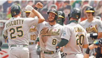  ?? Scott Strazzante / The Chronicle ?? Robbie Grossman elbowbumps Stephen Piscotty after Piscotty’s threerun home run during the A’s ninerun fifth inning against the Giants at Oracle Park in San Francisco.