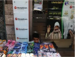  ?? (Ammar Awad/Reuters) ?? A STREET VENDOR sits near his stall in Amman yesterday.