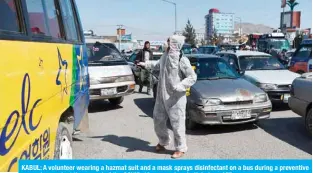  ??  ?? KABUL: A volunteer wearing a hazmat suit and a mask sprays disinfecta­nt on a bus during a preventive campaign against the spread of the COVID-19 coronaviru­s in Kabul. — AFP