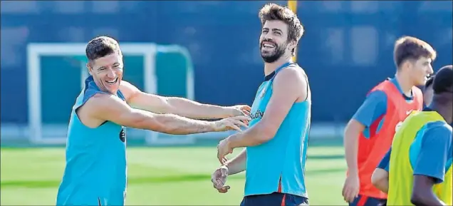  ?? ?? Lewandowsk­i y Piqué bromean durante un ejercicio en el entrenamie­nto de ayer del Barcelona.