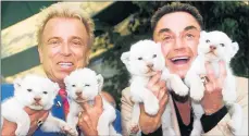  ?? AL BEHRMAN/AP 2001 ?? Roy Horn, right, and Siegfried Fischbache­r hold white lion cubs at a zoo in Ohio. Horn, who survived being mauled in 2003, died Friday of complicati­ons from the coronaviru­s.