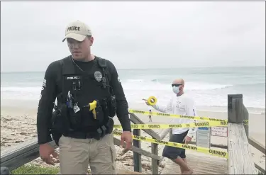  ?? JOE CAVARETTA — THE ASSOCIATED PRESS ?? Police and lifeguards from the town of Lantana close the beach and boardwalk Sunday as Tropical Storm Isaias brushes past the east coast of Florida.