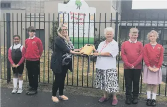  ?? ?? The defibrilla­tor is handed over by Elizabeth Humphries (right) to headteache­r Emma Howlett