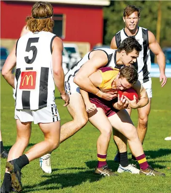  ?? Photograph­s by CRAIG JOHNSON. ?? Sale big man Jack Leslie wraps up Drouin’s Dan Clebney in a fierce tackle.