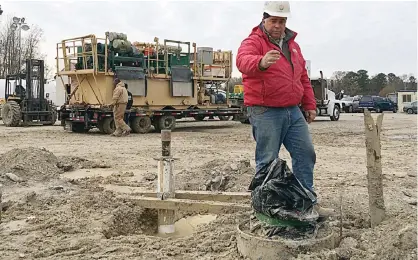  ??  ?? SUFFOLK: In this file photo, David Nelms, a hydrologis­t with the US Geological Survey, gestures to an extensomet­er that’s being installed in Suffolk, Virginia. —AP