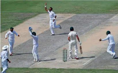  ?? AFP ?? Pakistan’s Bilal Asif (third right) celebrates after taking the wicket of Australian batsman Usman Khawaja during the third day of play of the first Test match at the Dubai Internatio­nal Stadium on Tuesday. —