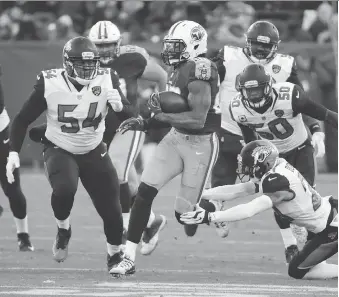  ?? JAMES KENNEY/AP ?? Canadian Eli Ankou, left, a Jacksonvil­le Jaguars defensive lineman, has made an impact with the NFL team in his rookie year.