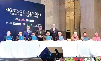  ?? ?? MCORP’s chief executive officer Datuk Mohd Yusof Abu Bakar (seated fourth left) and Teladan’s Teo Lay Ban (seated second left), signed a MoUg to develop a 341.2-acre German Technology Park in Melaka, in the presence of the Chief Minister of Melaka RaufYusoh (standing centre), Melaka State Secretary Datuk Wira Zaidi Johari (standing left), and Blomeyer (standing right).