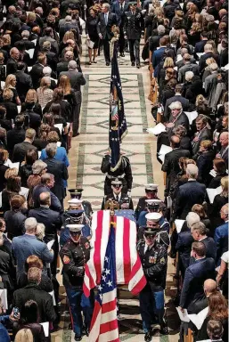  ?? [PHOTO BY DOUG MILLS, THE NEW YORK TIMES VIA AP, POOL] ?? The flag-draped casket of former President George H.W. Bush is carried out by a military honor guard during a State Funeral at the National Cathedral on Wednesday in Washington.