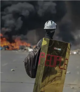  ?? FOTO: TT-AP ?? ■En demonstran­t framför brinnande bildäck i Myanmars största stad Rangoon förra veckan.