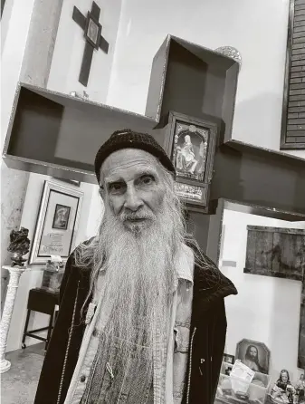  ?? Weihong ?? Forrest Prince, who was revered for his gentle, generous spirit and his righteous art, posed in 2019 in his last studio. The large cross-shaped piece behind him remains unfinished.