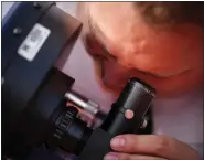  ?? JON SHAPLEY — HOUSTON CHRONICLE VIA THE ASSOCIATED PRESS ?? Jonathan Schiller, who does public outreach work for the Fiske Planetariu­m, looks through a telescope Monday ahead of the total solar eclipse at Eagle Pass Student Activities Center in Eagle Pass, Texas.