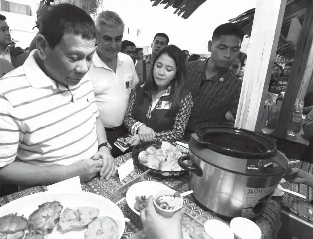 ?? PHOTO BY TOTO LOZANO/ PRESIDENTI­AL PHOTO ?? President Rodrigo Roa Duterte visits one of the food stalls during the Department of Tourism's Food and Travel Festival dubbed ‘Kaon Ta!' held at the Abreeza Mall in Davao City on December 7, 2018. Also in the photo are Ayala Corporatio­n Chairman and Chief Executive Officer Jaime Zobel de Ayala and Tourism Secretary Bernadette Puyat