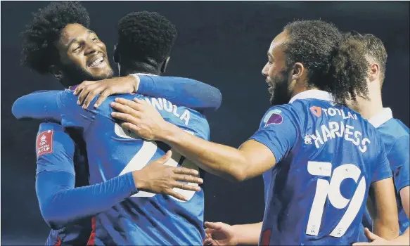  ?? Pictures: PinPeP ?? OFF THE MARK Jordy Hiwula gets a hug from Ellis Harrison after scoring his maiden Pompey goal in style with a classy strike against King’s Lynn.