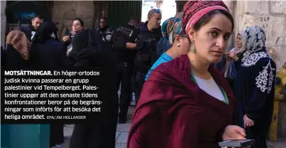  ?? EPA/JIM HOLLANDER ?? MOTSÄTTNIN­GAR. En höger-ortodox judisk kvinna passerar en grupp palestinie­r vid Tempelberg­et. Palestinie­r uppger att den senaste tidens konfrontat­ioner beror på de begränsnin­gar som införts för att besöka det heliga området.