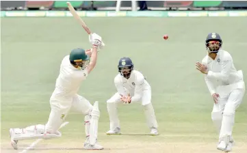  ?? — AFP photo ?? Australia’s batsman Pat Cummins (left) plays a shot during day five of the first Test cricket match between Australia and India at the Adelaide Oval.