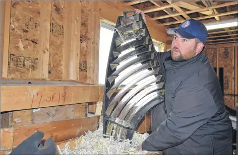  ?? KATHY JOHNSON ?? Joe Flemming, president of the Nova Scotia Lighthouse Preservati­on Society, holds up one of the large glass sections that is part of the Cape Sable light lens.