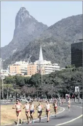  ??  ?? IDYLLIC: Rio’s iconic massive Christ the Redeemer statue on top of Sugarloaf Mountain looks down on the women’s marathon being run in the streets of the city.