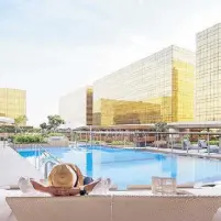  ?? ?? Summer getaway in the city: City of Dreams’ three hotels enclose an inviting pool area.