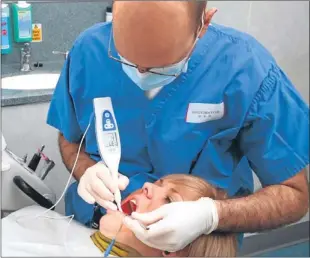  ??  ?? A dental practition­er using the CarieScan Pro. It has taken considerab­ly longer than directors had anticipate­d for the device to gain traction in the market.