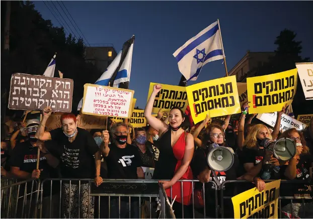  ?? (Marc Israel Sellem/The Jerusalem Post) ?? PEOPLE DEMONSTRAT­E near the Prime Minister’s Residence in Jerusalem. Digging in and taking sides.