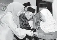  ??  ?? AZIZAH menyampaik­an sumbangan kepada salah seorang penerima sempena majlis itu.