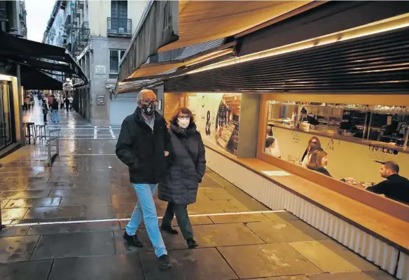  ?? Foto: Javier Bergasa ?? Una pareja con mascarilla pasea junto a un bar en la calle San Nicolás.