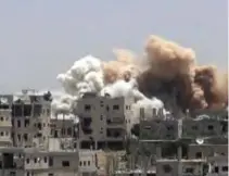  ?? — AP ?? DARAA, Syria: This frame grab from video provided yesterday shows smoke rising over buildings that were hit by Syrian government forces bombardmen­t.