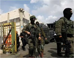  ?? (Ronen Zvulun/Reuters) ?? SOLDIERS PATROL at the scene of the Barkan industrial park terrorist attack last month.